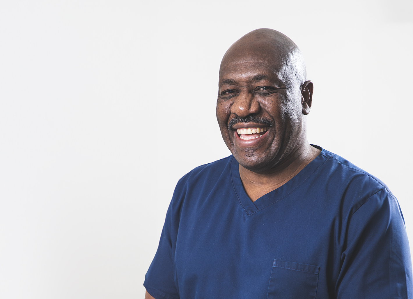 Man in blue medical tunic smiling